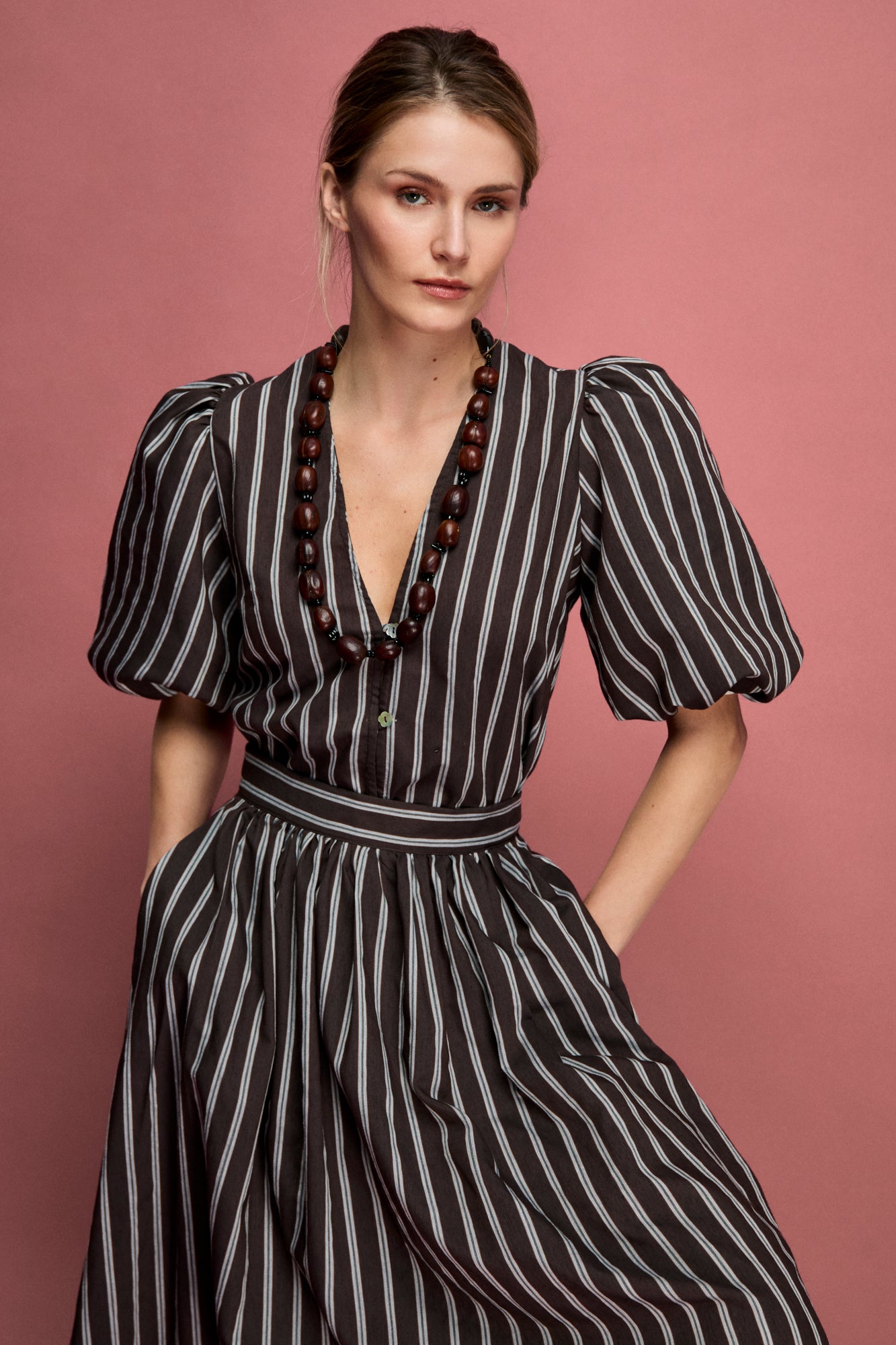Blusa de rayas en color marron con manga fruncida al codo y escote en uve.