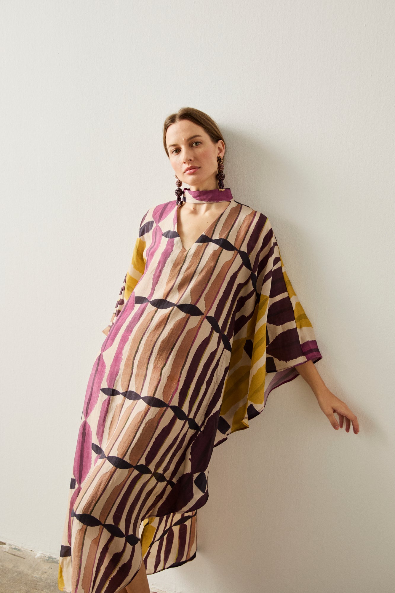 Vestido fiesta con manga de murciélago y aberturas en los laterales de la falda.