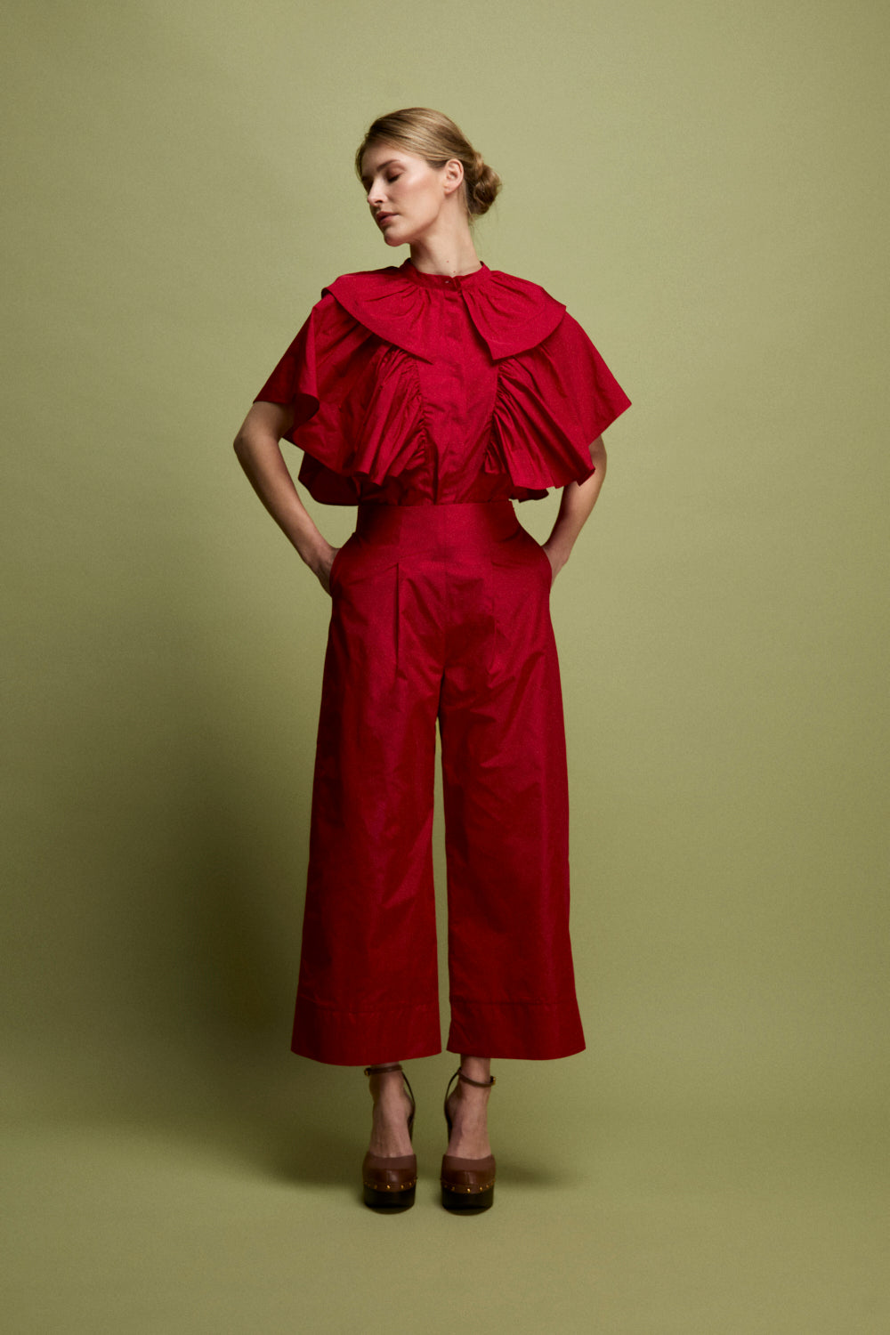 Blusa confeccionada en tafeta en color carmín con frunces y volantes en mangas.