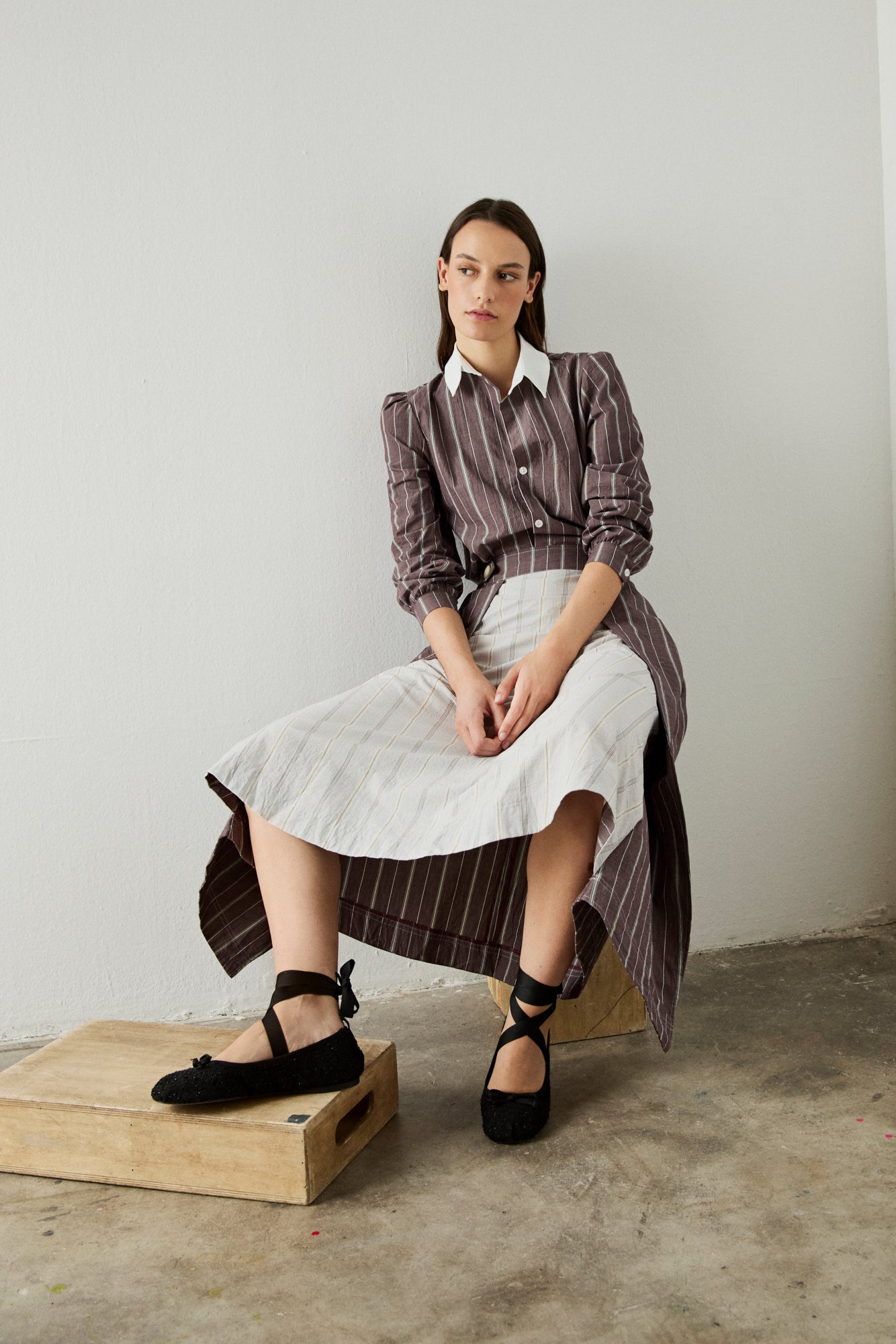 Camisa burdeos y blanca, con manga abullonada.