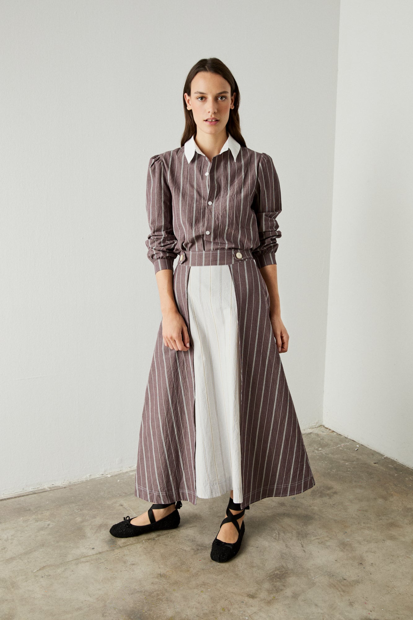 Camisa de rayas en color berenjena de manga larga, hombros rizados y puño abotonado.